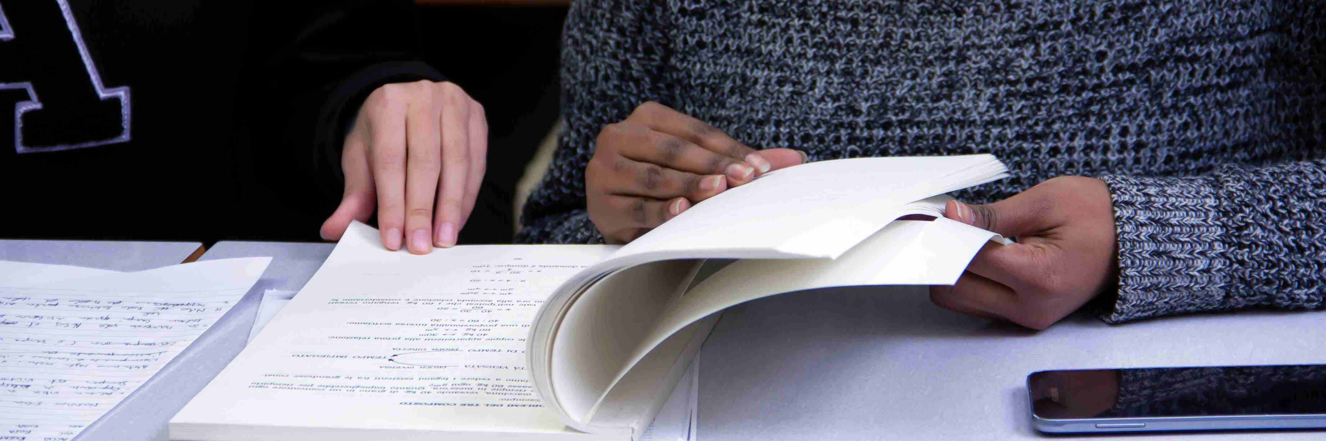 two students studying on the same shared paper book