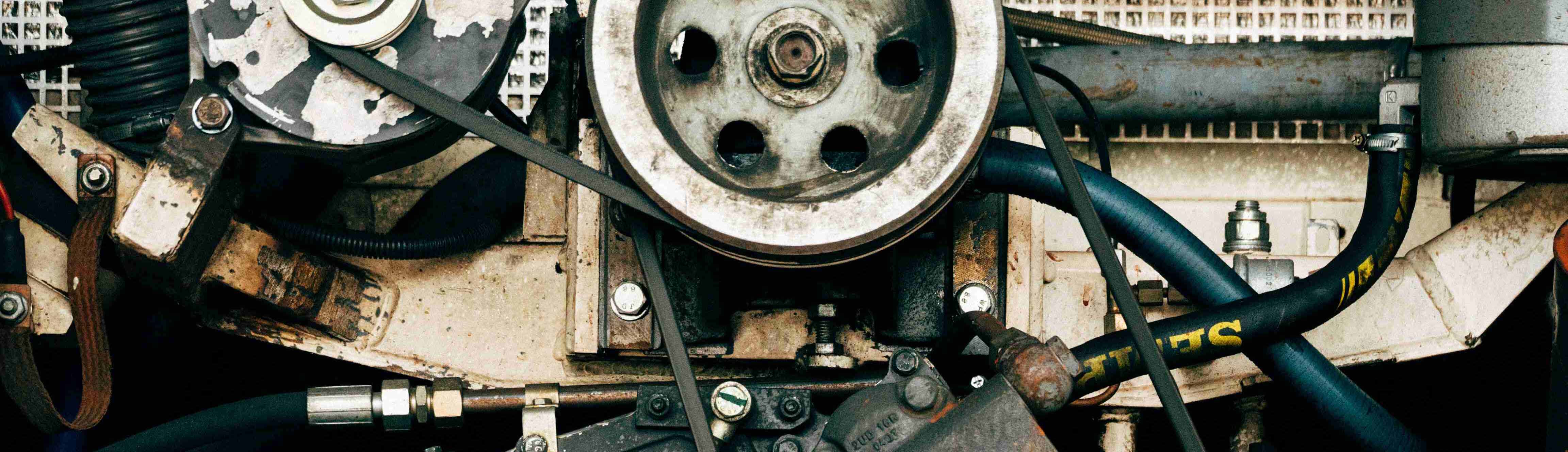 big cyberpunk looking rusted engine pulley with gears on a wall to represent automation